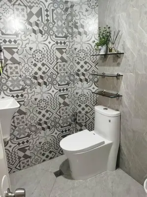 a bathroom with a toilet and a tile wall at Samong Transient House in Imus