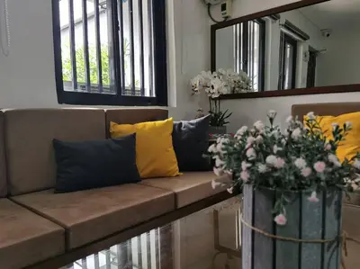a brown couch with yellow pillows and flowers on it at Samong Transient House in Imus