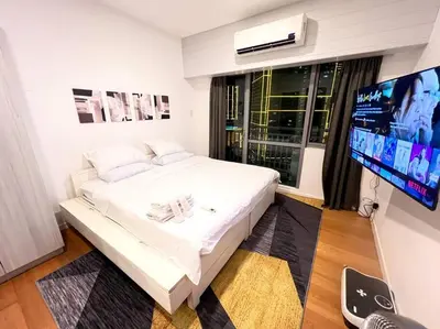 a bedroom with a white bed and a flat screen tv at Rockwell View Acqua Iguazu Tower 17th flr Mandaluyong-Makati 1BR in Manila