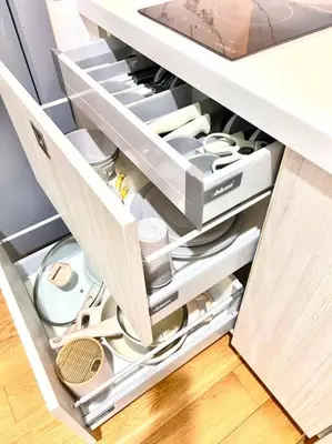 an open drawer in a kitchen cabinet with dishes at Rockwell View Acqua Iguazu Tower 17th flr Mandaluyong-Makati 1BR in Manila