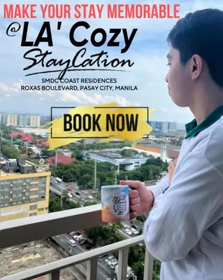 a man holding a cup of coffee on a balcony at Flat in Pasay-Coast Residences in Manila