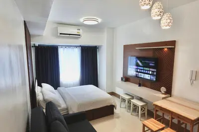 a hotel room with a bed and a desk and a television at Modern Lux at Shore 3 Tower 4 SMDC Pool View in Manila