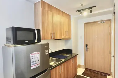 a small kitchen with a refrigerator and a microwave at Modern Lux at Shore 3 Tower 4 SMDC Pool View in Manila