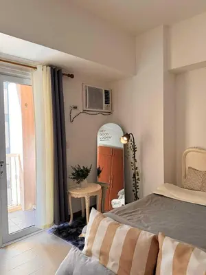 a bedroom with a bed and a window at Venice Vista Lodge Staycation connected to Venice Grand Canal in Manila