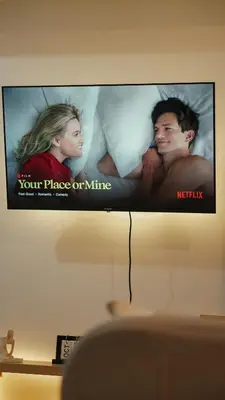 a television screen with a picture of a man and a woman at Venice Vista Lodge Staycation connected to Venice Grand Canal in Manila