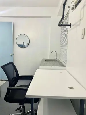 an office with a white desk and a black chair at Cedar House in Manila