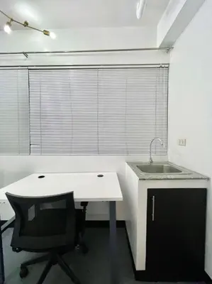 a kitchen with a sink and a table and a chair at Cedar House in Manila