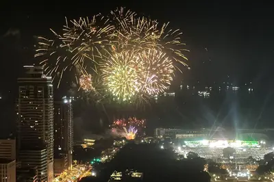 a fireworks display in a city at night at \u9a6c\u5c3c\u62c9\u6e7e\u4e09\u623f\u516c\u5bd3 in Manila