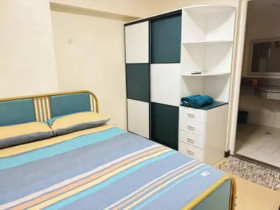 a bedroom with a bed and a white dresser at \u9a6c\u5c3c\u62c9\u6e7e\u4e09\u623f\u516c\u5bd3 in Manila