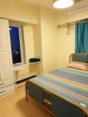 a small room with a bed and a window at \u9a6c\u5c3c\u62c9\u6e7e\u4e09\u623f\u516c\u5bd3 in Manila