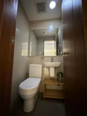 a small bathroom with a toilet and a sink at Newly Renovated 2-Storey Loft at Greenbelt 1 in Manila