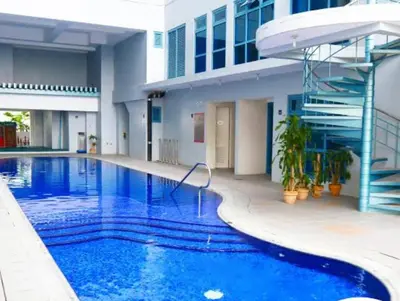 a large blue swimming pool in front of a building at Newly Renovated 2-Storey Loft at Greenbelt 1 in Manila