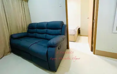 a blue couch in a room with a mirror at EJ Homes - Shore 3 Residences in Manila