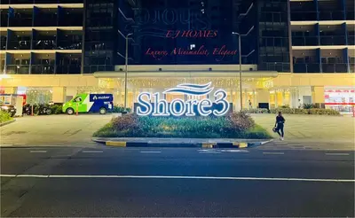 a person walking down a street in front of a building at EJ Homes - Shore 3 Residences in Manila
