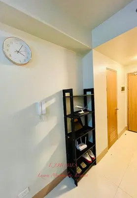 a clock on a wall next to a shelf at EJ Homes - Shore 3 Residences in Manila