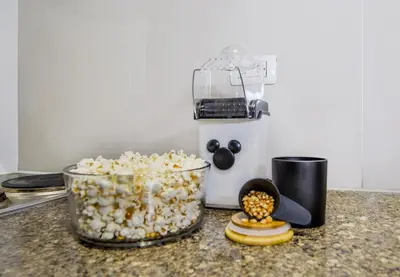 a bowl of popcorn sitting on a counter next to a food processor at Vintage Mickey Disney Stay in BGC -200mbps wifi in Manila