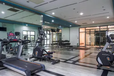 a gym with several treadmills and elliptical machines at Vintage Mickey Disney Stay in BGC -200mbps wifi in Manila