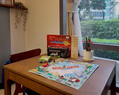 a table with a board game and a book on it at Vintage Mickey Disney Stay in BGC -200mbps wifi in Manila