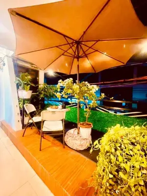 a patio with a table and chairs and an umbrella at Subway House in Paranaque in Manila