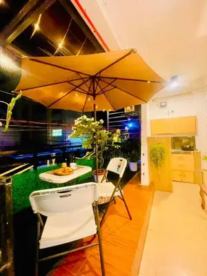 a table and chairs with an umbrella in a kitchen at Subway House in Paranaque in Manila