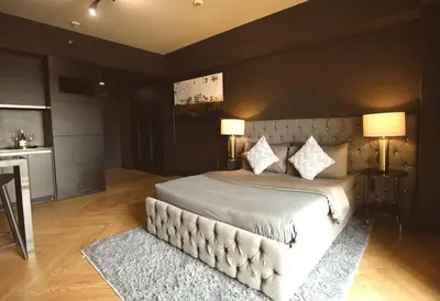 a bedroom with a bed with two lamps and a rug at Italian Style Unit in Venice Luxury Residences in Manila
