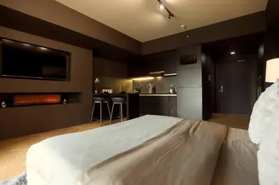 a bedroom with a large white bed and a kitchen at Italian Style Unit in Venice Luxury Residences in Manila