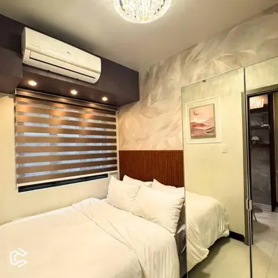 a bedroom with two white beds and a window at Crib2Go Benz Suite with Pool View in Manila