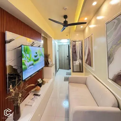 a living room with a couch and a flat screen tv at Crib2Go Benz Suite with Pool View in Manila