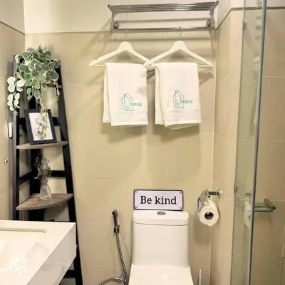 a bathroom with a toilet and a sign that says be kind at Crib2Go Benz Suite with Pool View in Manila