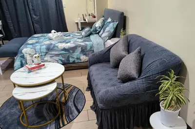a living room with a couch and a bed at Studio Type Condotel at Venice McKinley Taguig City in Manila