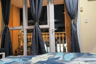 a bedroom with blue curtains in front of a window at Studio Type Condotel at Venice McKinley Taguig City in Manila
