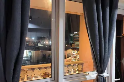 a window with black curtains and a view of a city at Studio Type Condotel at Venice McKinley Taguig City in Manila