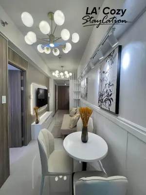 a living room with a table and chairs at Smdc Coast Residences- LA Cozy Staycation in Manila