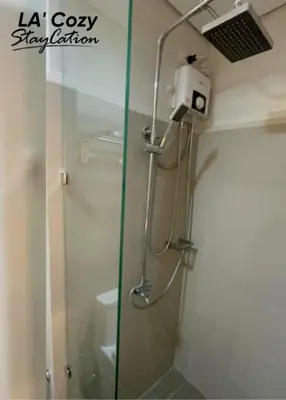 a shower with a glass door in a bathroom at Smdc Coast Residences- LA Cozy Staycation in Manila
