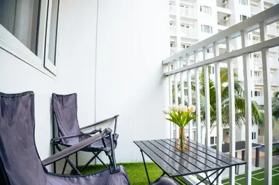 a table and chairs on a balcony with a vase of flowers at 1bedroom with Balcony facing pool Near MOA in Manila