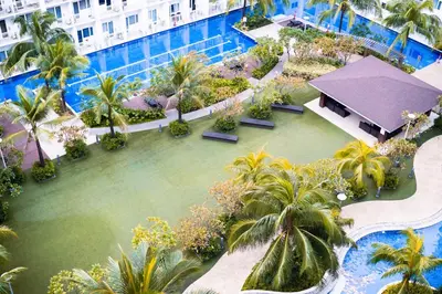 an aerial view of a resort pool with palm trees at 1bedroom with Balcony facing pool Near MOA in Manila