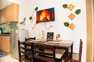 a kitchen with a table with a fireplace on the wall at 1bedroom with Balcony facing pool Near MOA in Manila