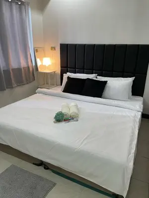 a large white bed with two towels on it at A-South of Market SOMA in Manila