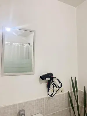 a hair dryer on a wall in a bathroom at A-South of Market SOMA in Manila