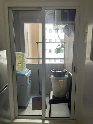 a glass door of a room with a window at A-South of Market SOMA in Manila