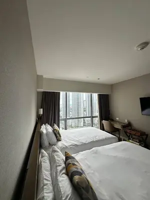 a hotel room with two beds and a window at The Metro Zen at Hotel Residences Acqua - Novotel Tower in Manila