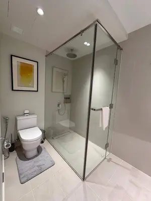 a bathroom with a glass shower and a toilet at The Metro Zen at Hotel Residences Acqua - Novotel Tower in Manila