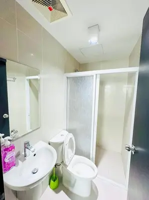 a bathroom with a toilet and a sink and a shower at Deryll's Fun house in Manila