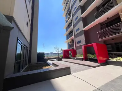 a view of a building with red furniture in a courtyard at Gentry Manor Balcony Green View WiFi Netflix Walk to Okada Casino 8J in Manila
