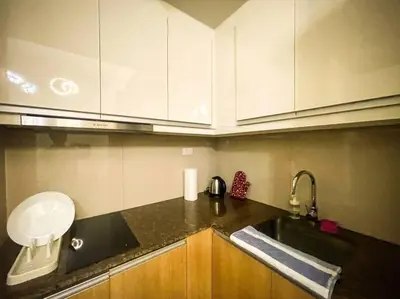 a kitchen with white cabinets and a black counter top at Luxury 1 Bedroom across Okada II Balcony w View in Manila