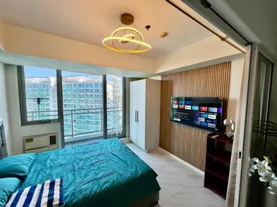 a bedroom with a bed and a large window at Azure South Bicutan spacious 1BR BEST view in Manila