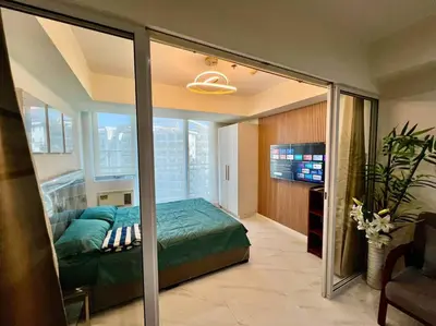 a bedroom with a bed and a large window at Azure South Bicutan spacious 1BR BEST view in Manila