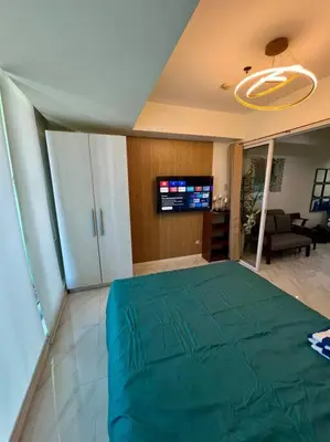 a bedroom with a large green bed in a room at Azure South Bicutan spacious 1BR BEST view in Manila