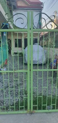 a green metal gate with a bed in it at Casa Regine in Manila