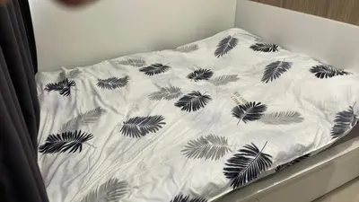 a bed with a white sheet with black leaves on it at Tower 3 Shore 2 High Floor 1BR Good 4PAX in Manila